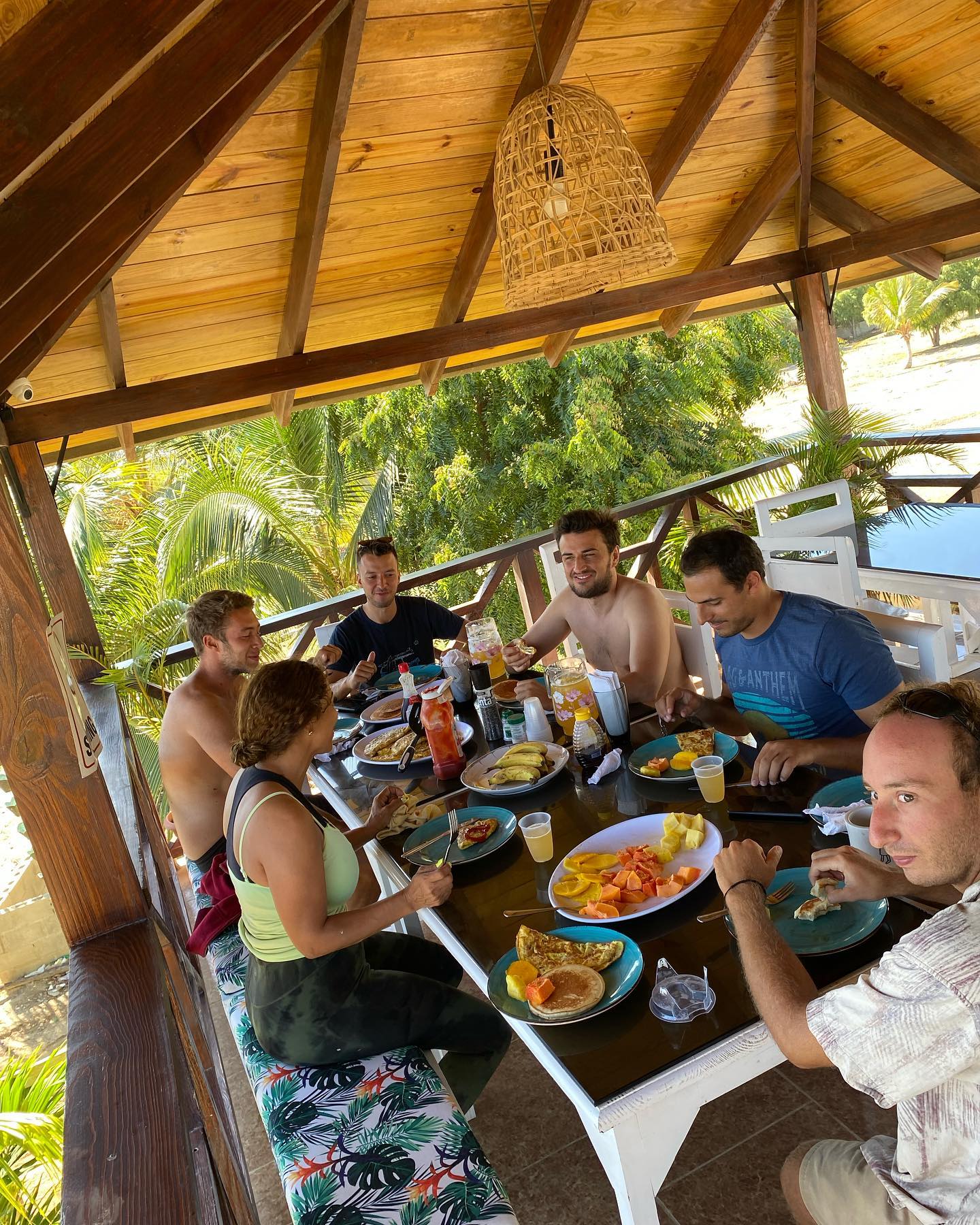 A group of people are sitting around a table eating food.