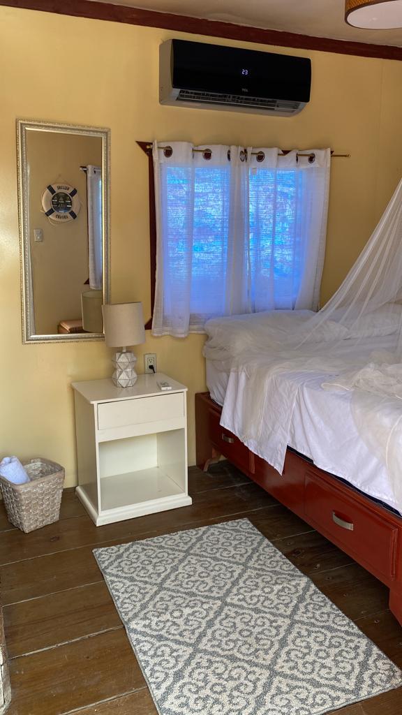 A bedroom with a bed , nightstand , rug and mirror.