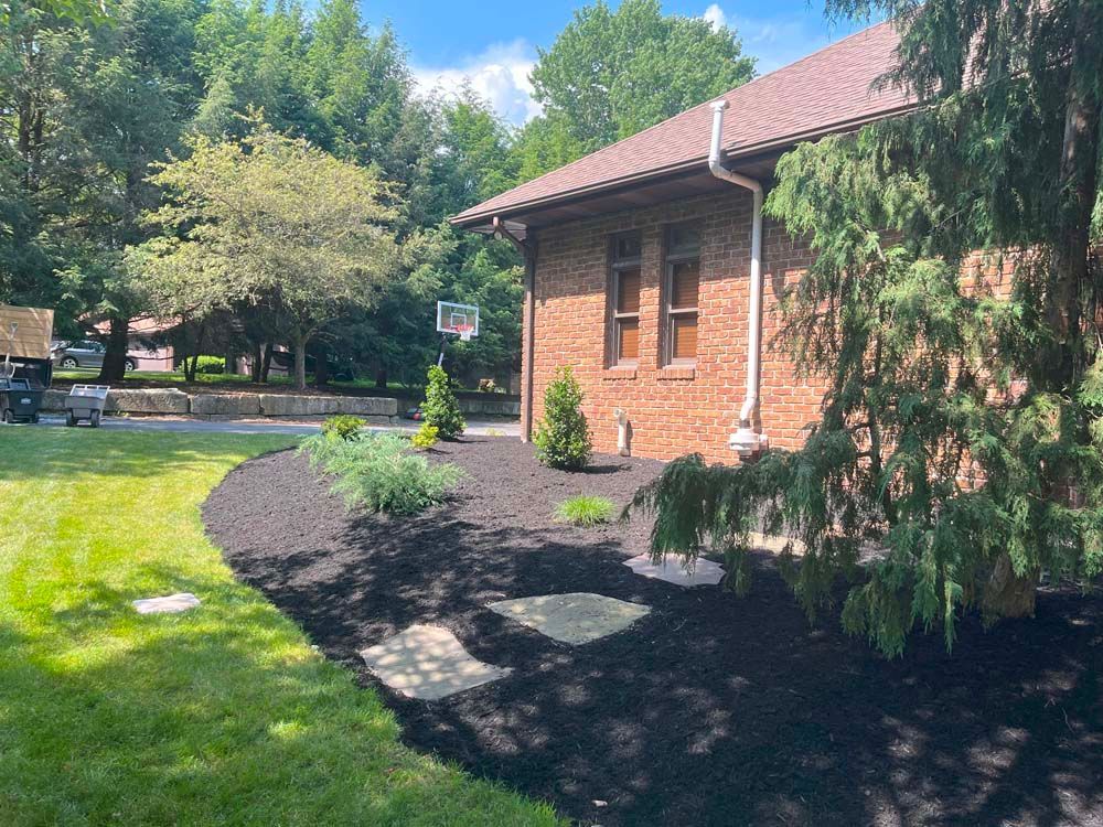 A brick house with a basketball hoop in the backyard.