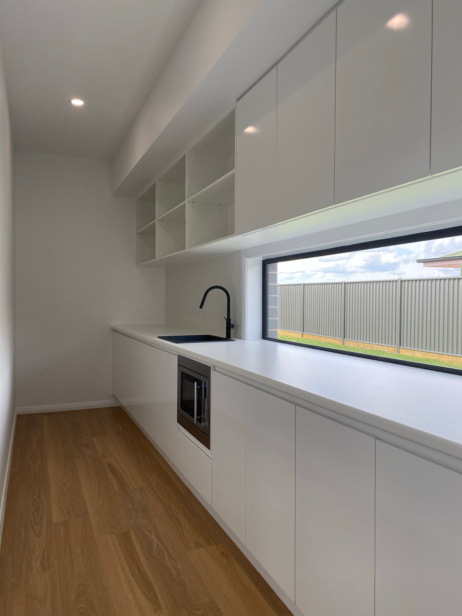 Empty White Countertop and Large Window — Kitchen Renovations in Dubbo, QLD