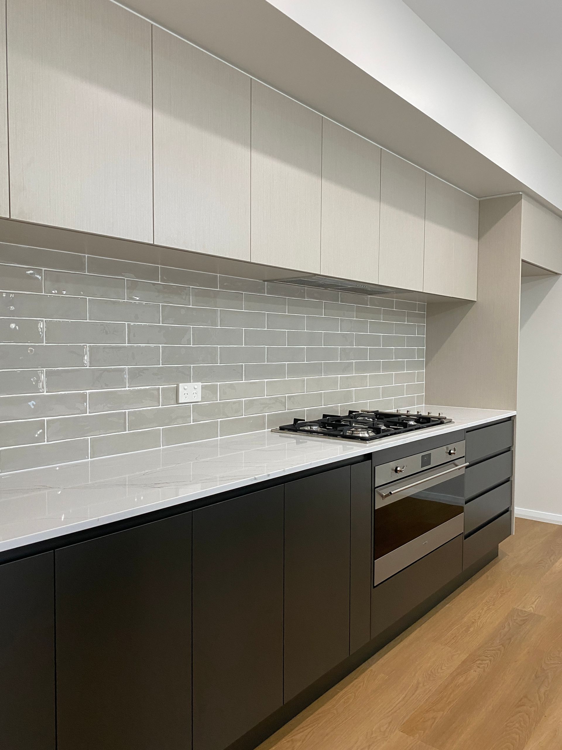Beautiful Marble Countertop With Black Cabinets and Stove — Kitchen Renovations in Dubbo, QLD