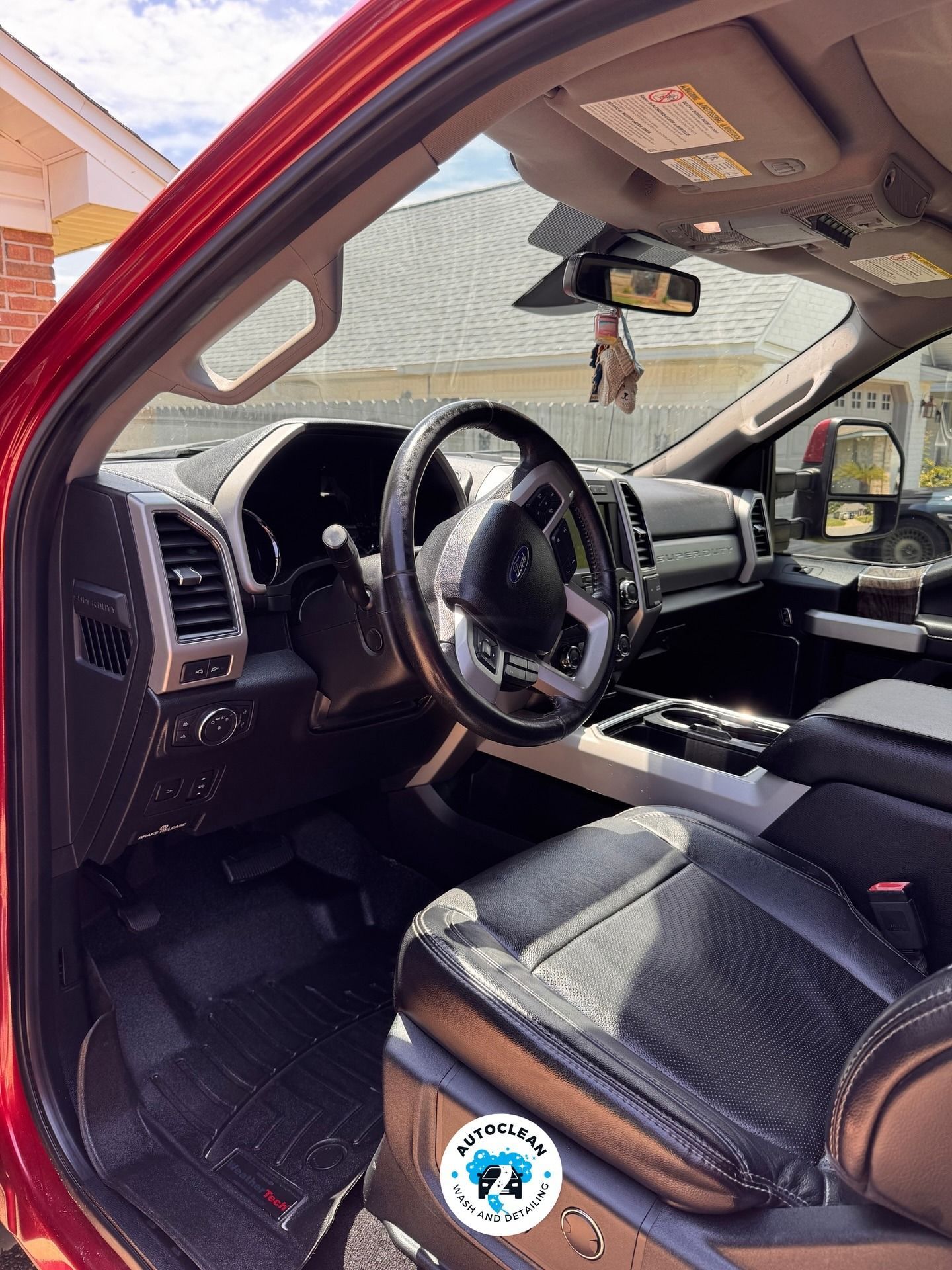 Interior of a black truck with leather seats, steering wheel, dashboard, and sunroof visible.