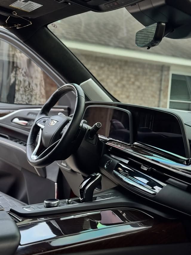Luxury car interior with black leather seats, glossy dashboard, and steering wheel