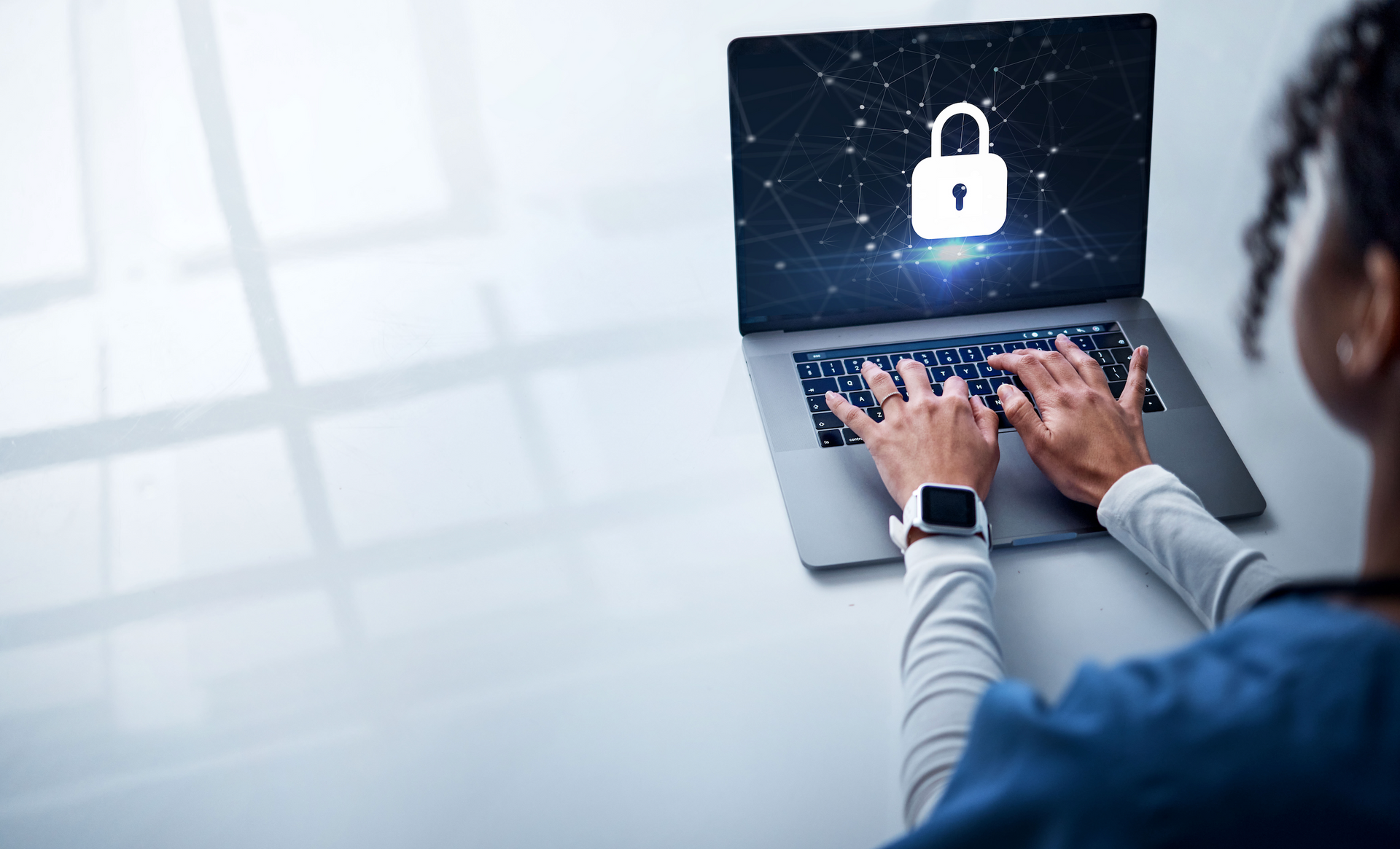 A woman is typing on a laptop computer with a padlock on the screen.