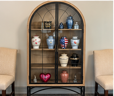Arched black display cabinet with colorful vases and decor between two beige chairs