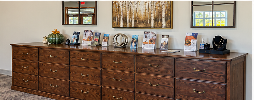 Wooden sideboard with framed photos, decor, and a mirror on a beige wall in a home dining area