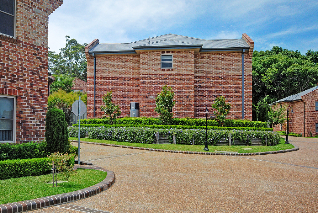 A brick house with a driveway in front of it