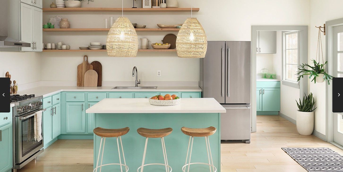 A bright, modern kitchen features light turquoise cabinets, an island with wooden stools, open shelving, and a refrigerator.