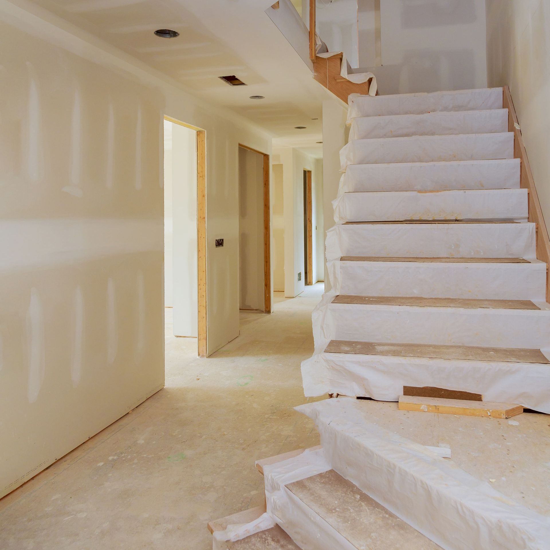 an empty hallway with stairs covered in plastic