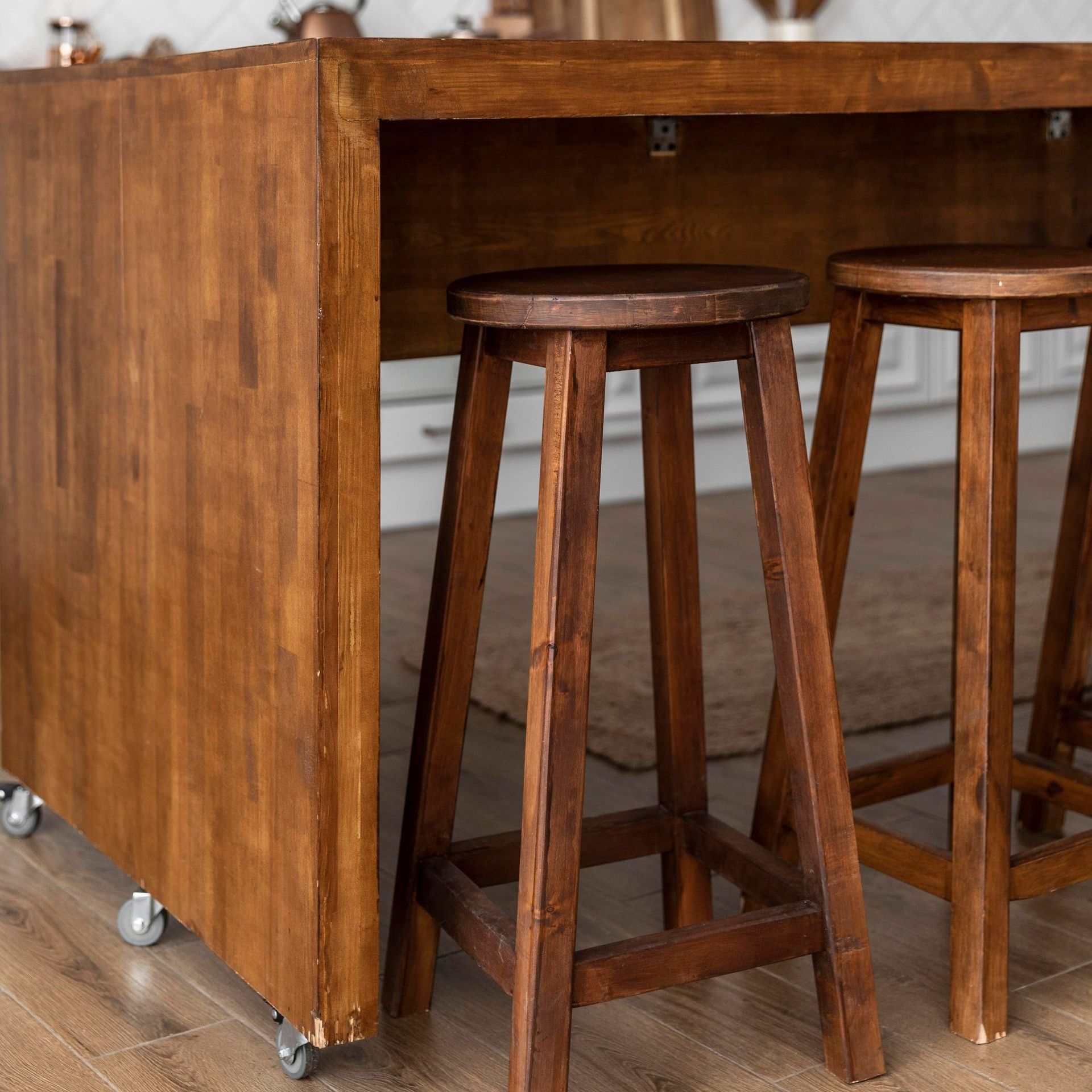 two wooden stools are sitting next to a wooden table .