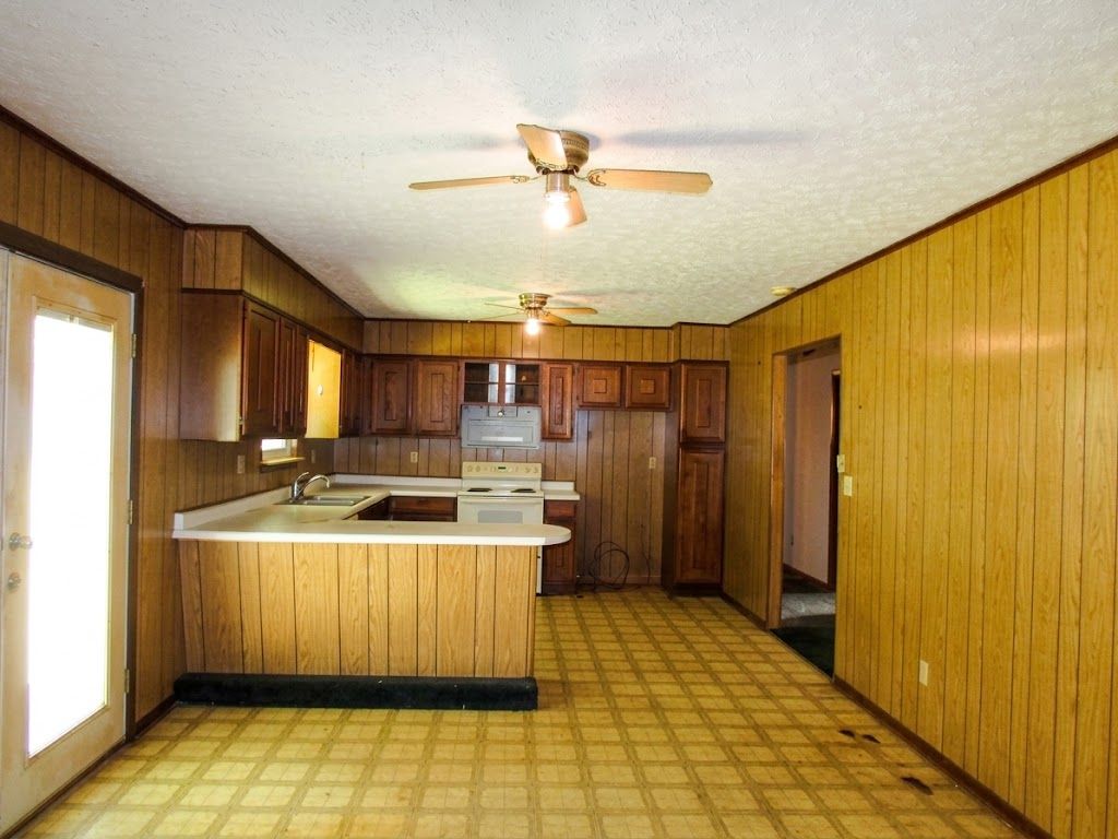 Wood-paneled kitchen with checkered floor, central island, and ceiling fans