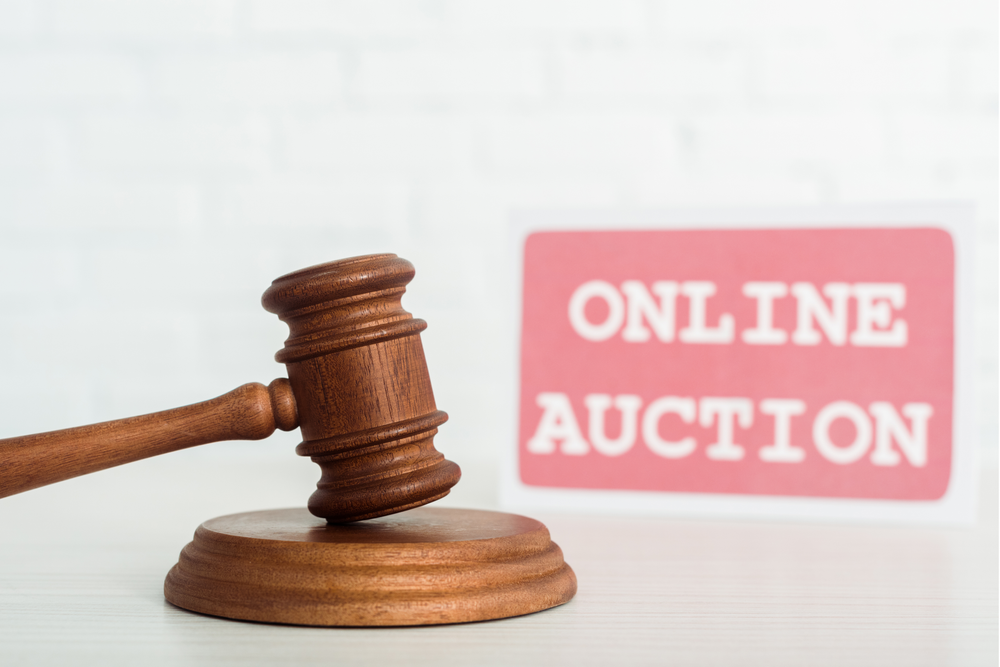 Gavel with an Online Auction Sign behind it