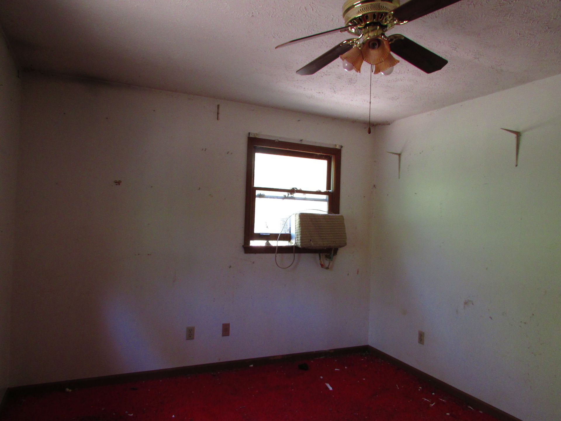 Empty room with white walls, red carpet, ceiling fan, and a window air conditioner