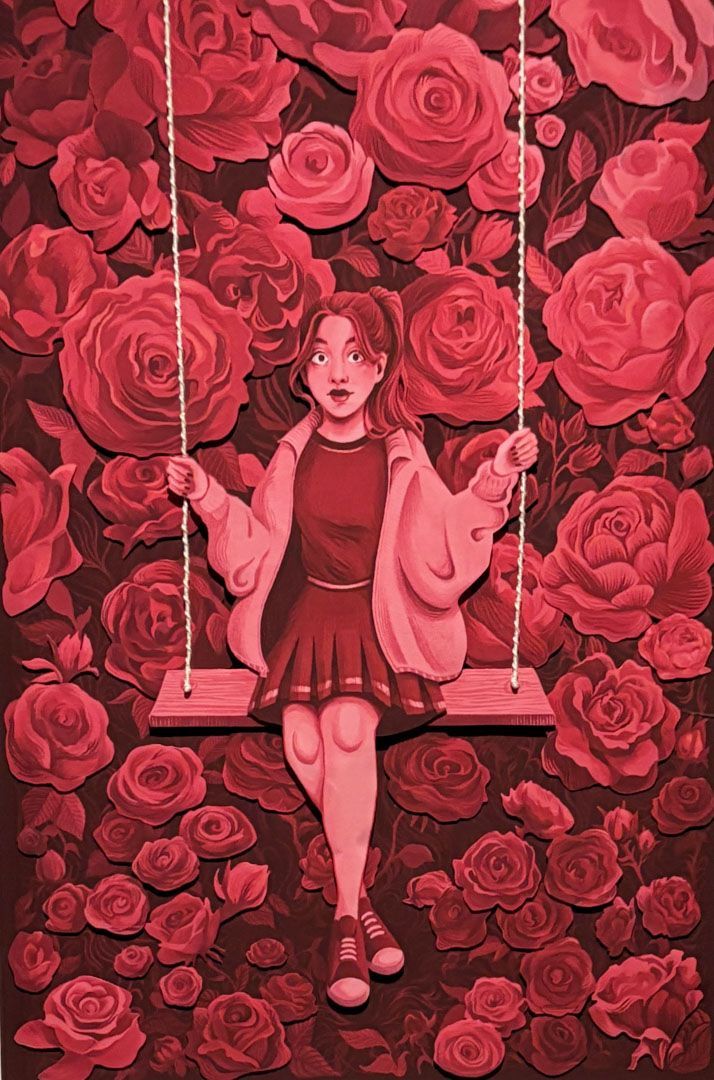 Woman on a swing in front of a wall of red roses. Wearing a jacket, skirt, and sneakers.