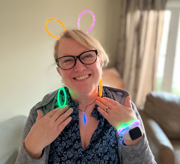 The woman owner of Twisted Stitch wearing glasses and glow in the dark bracelets