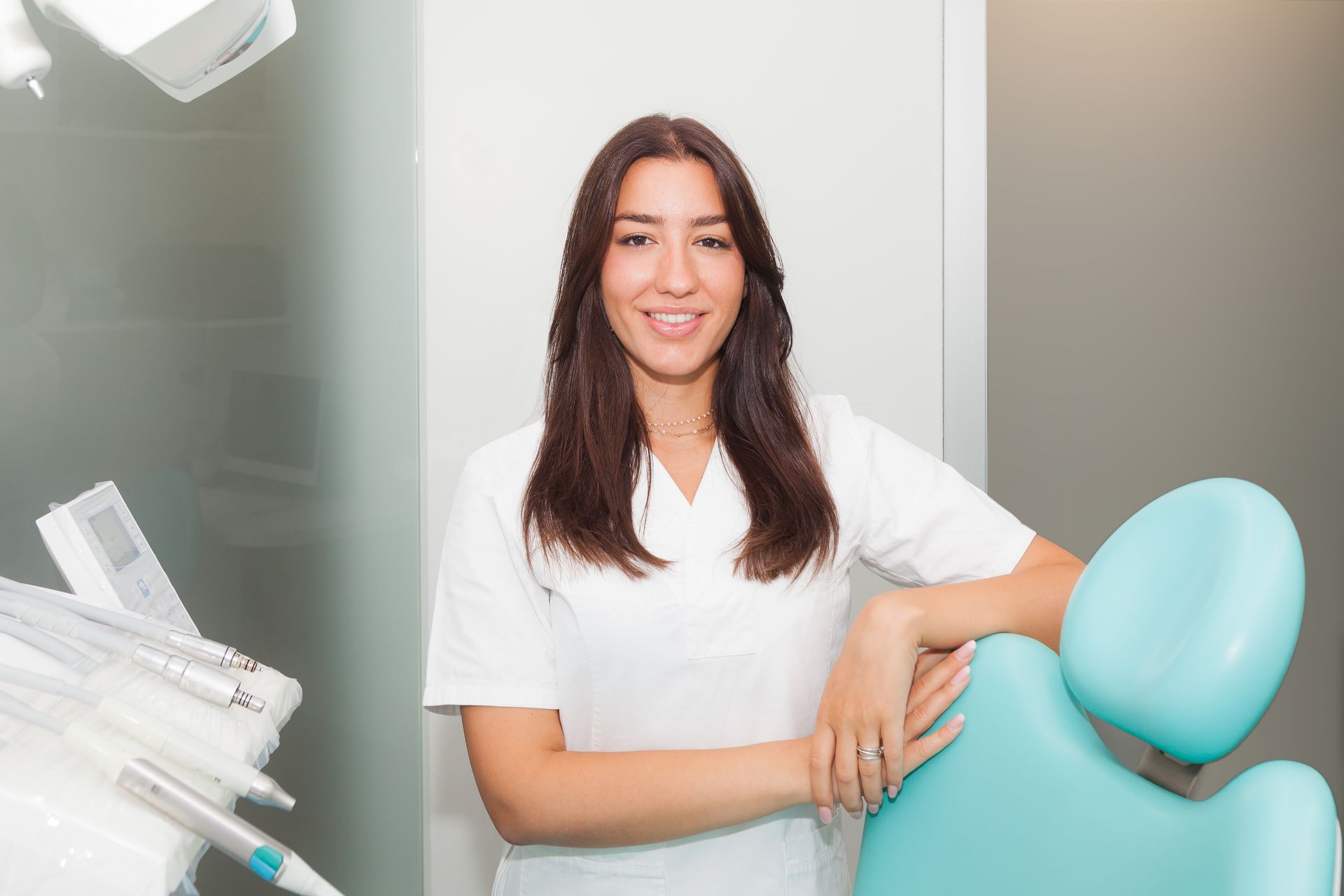 Una donna con una camicia bianca è in piedi in uno studio dentistico.