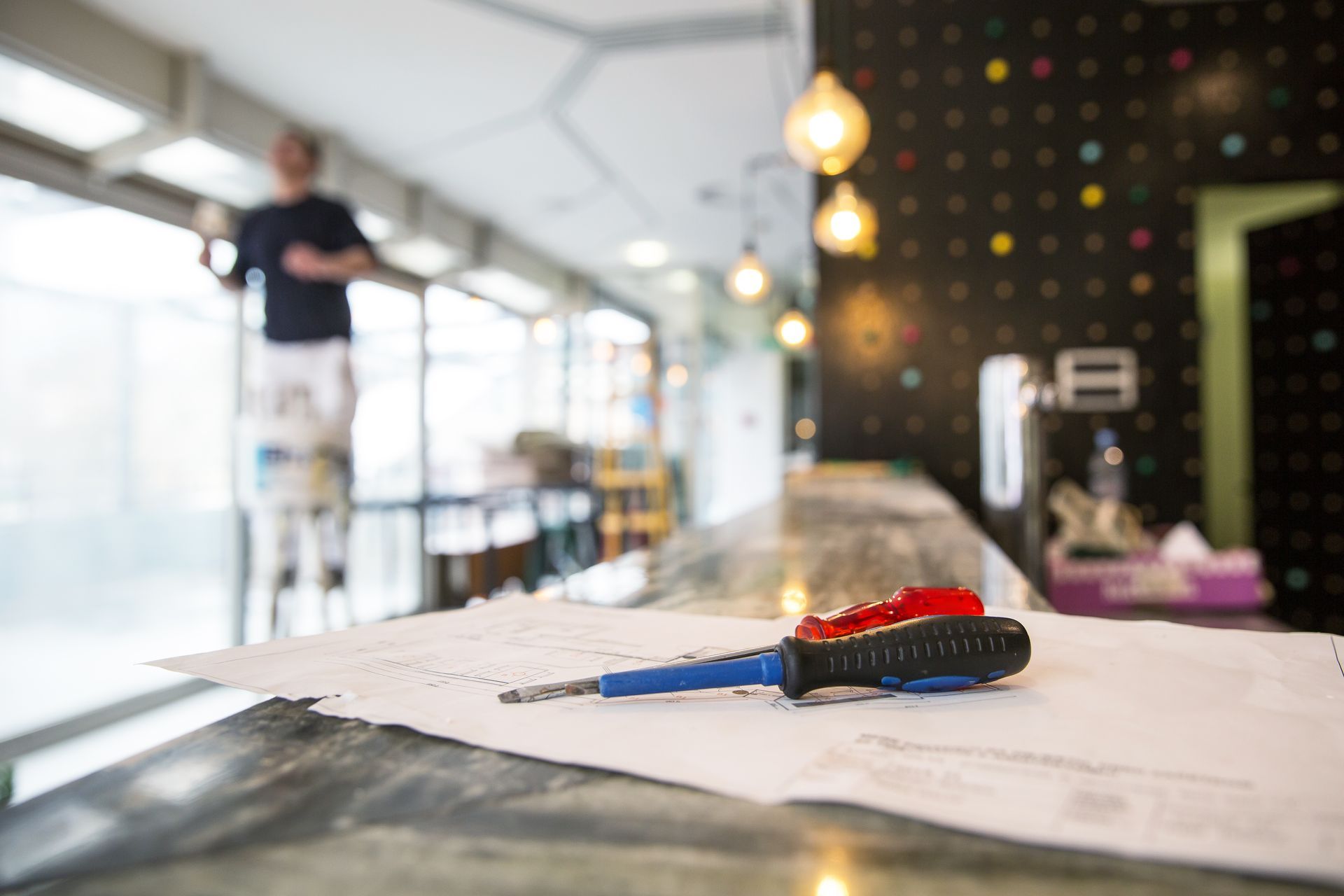 Clipboard with pen on table in a bright office, with a blurred person in the background