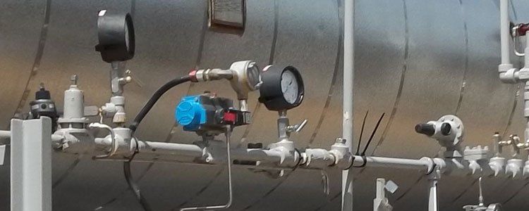 A bunch of pipes and gauges on a wall.