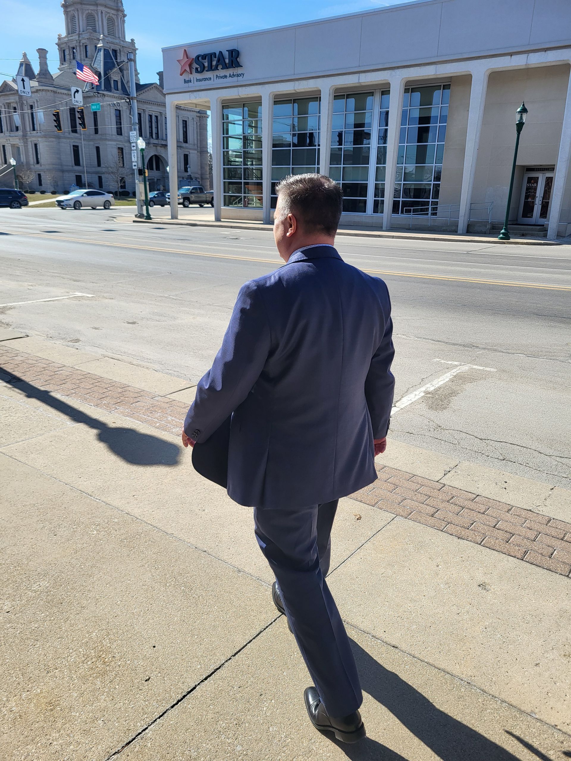 Brad Baber, attorney in Whitley County, walking to the Whitley County Courthouse in his blue suit.