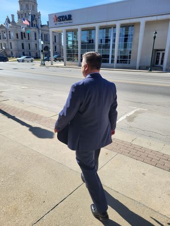 Brad Baber, attorney in Whitley County, walking to the Whitley County Courthouse in his blue suit.