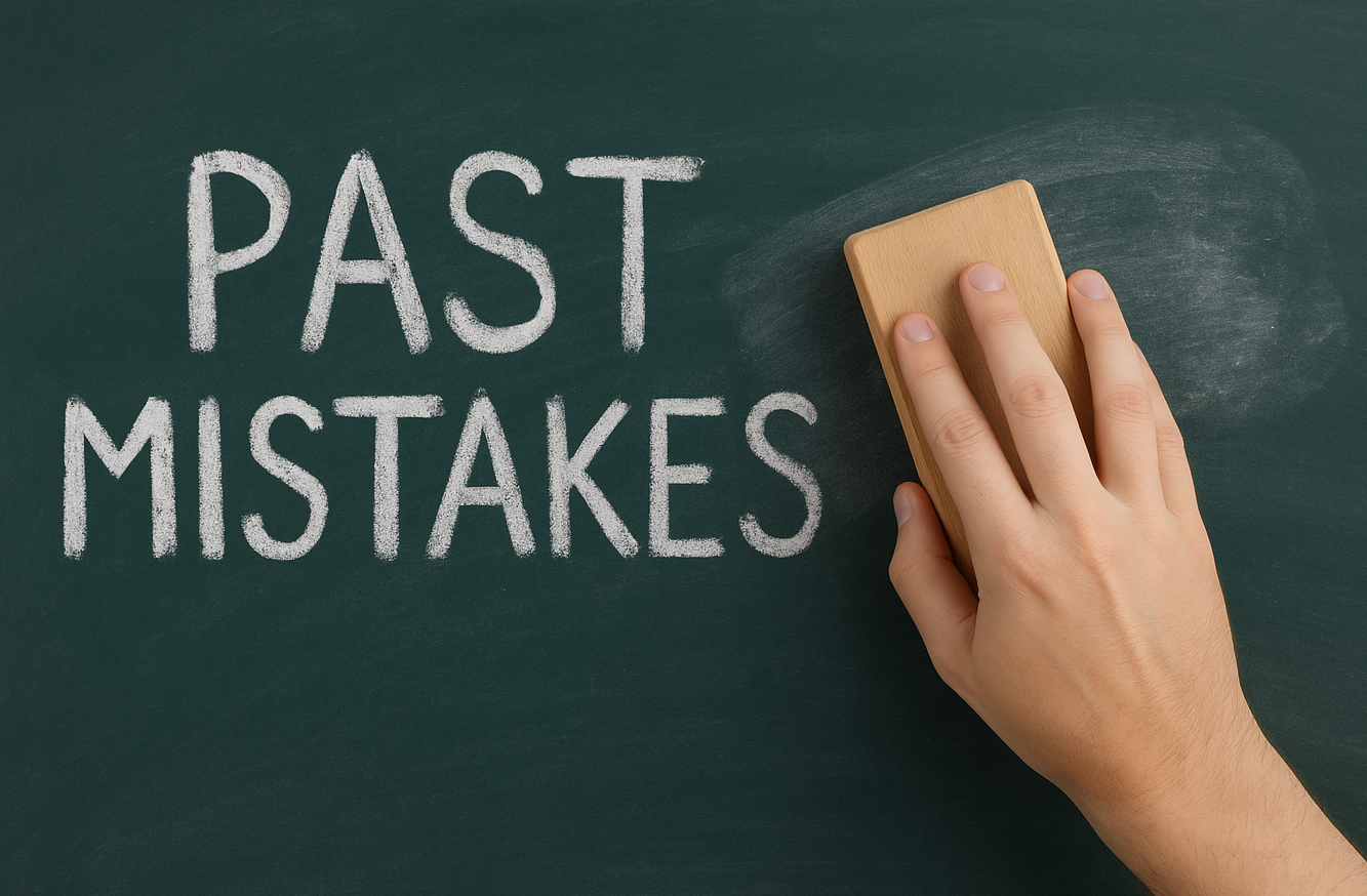 A hand wiping away the word 'PAST' written in chalk on a blackboard, symbolizing clearing a criminal record through expungement in Indiana.