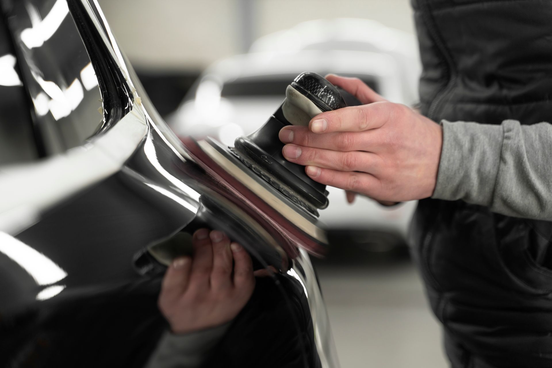 A person is polishing a car with a machine.