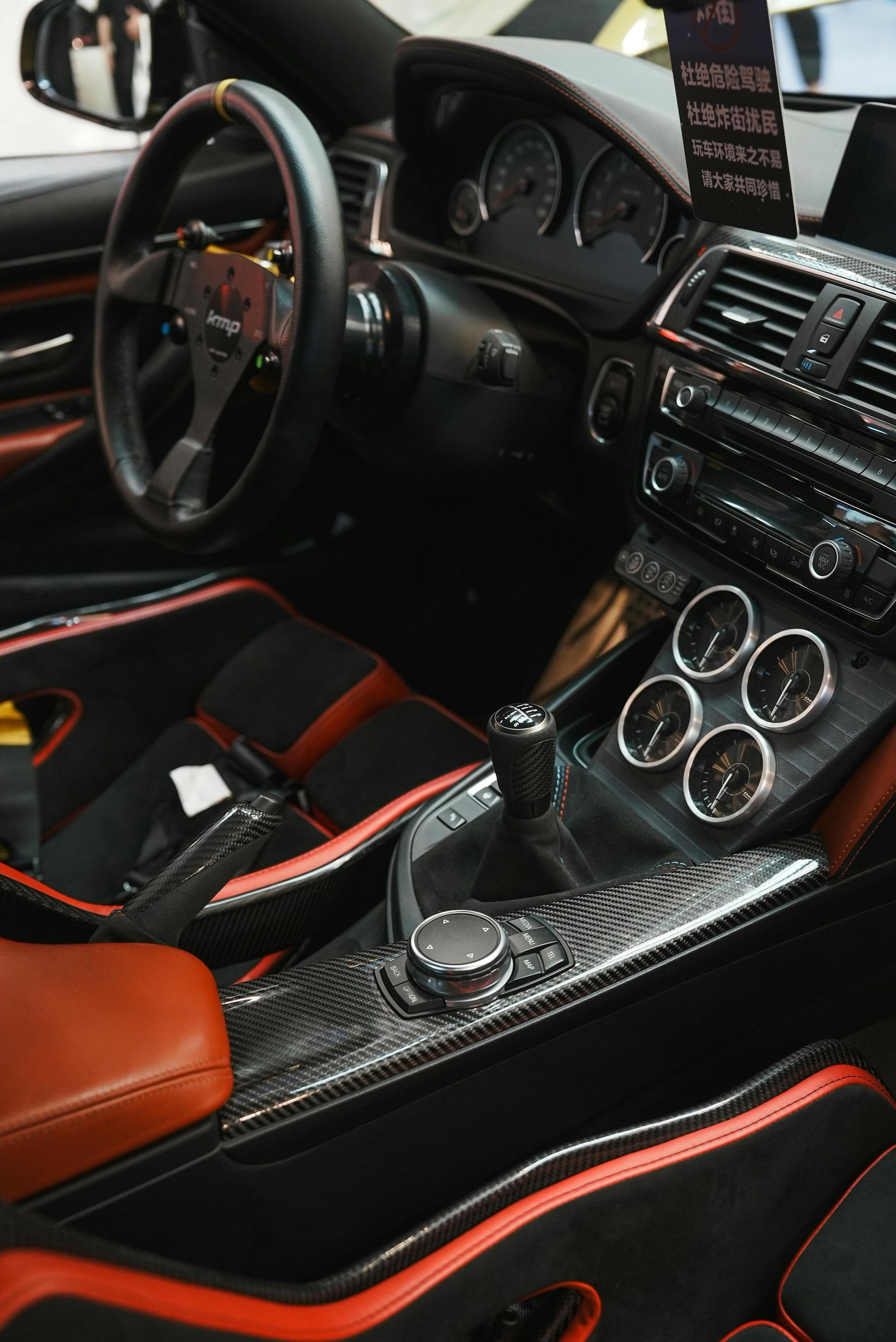 The interior of a car with red and black seats and a steering wheel.