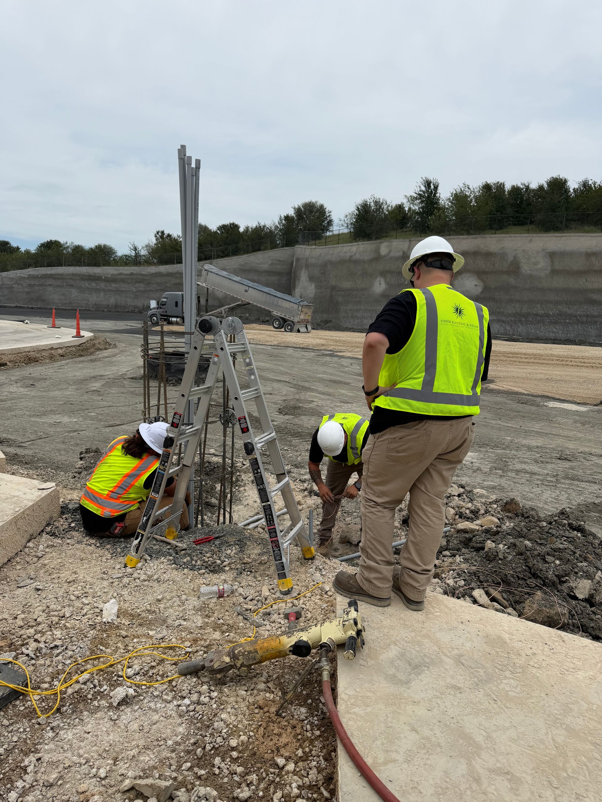 Construction workers in neon vests working on rebar at a roadwork site