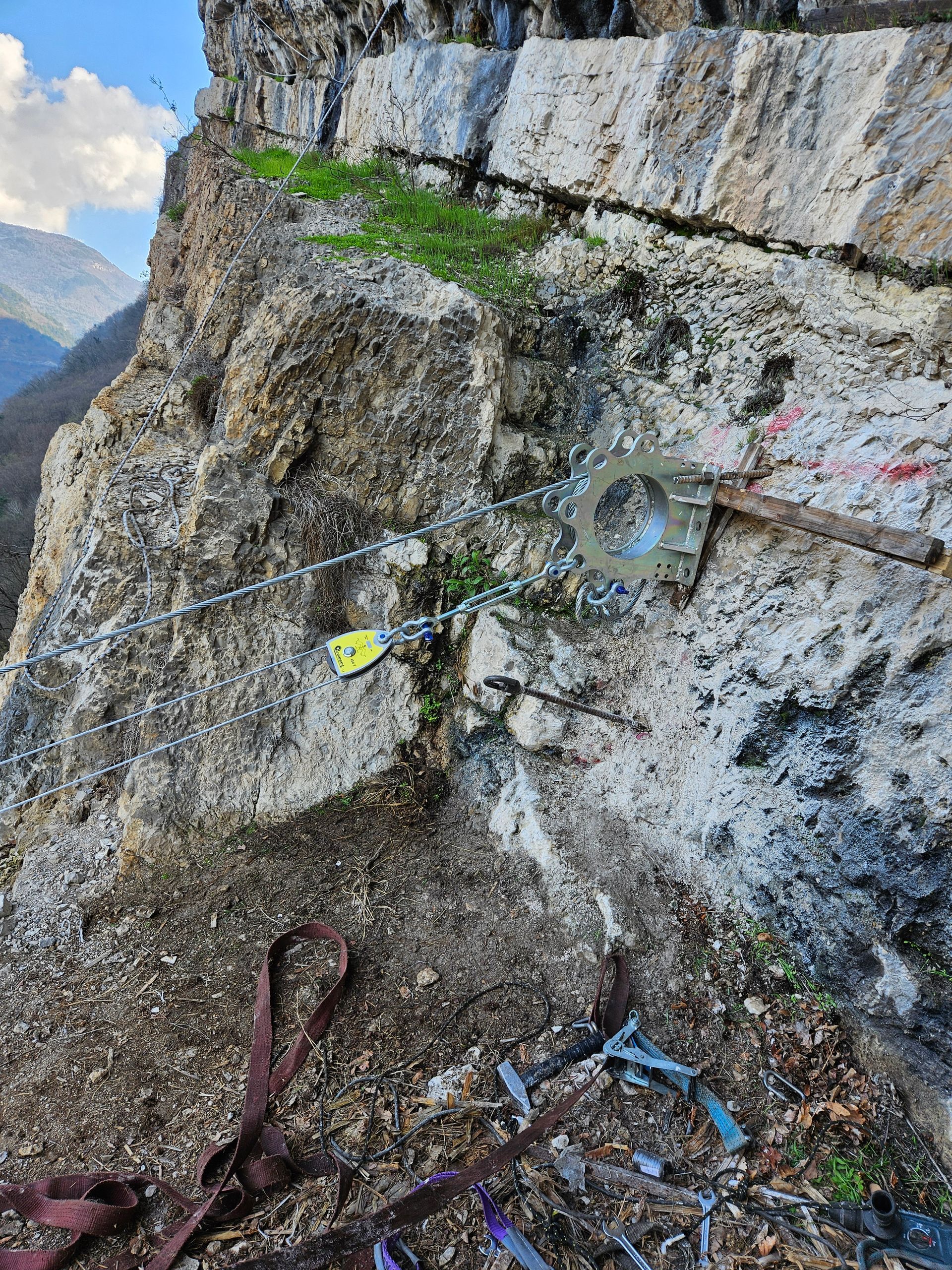 Ancoraggio per arrampicata su roccia con catena e moschettone su una parete rocciosa.