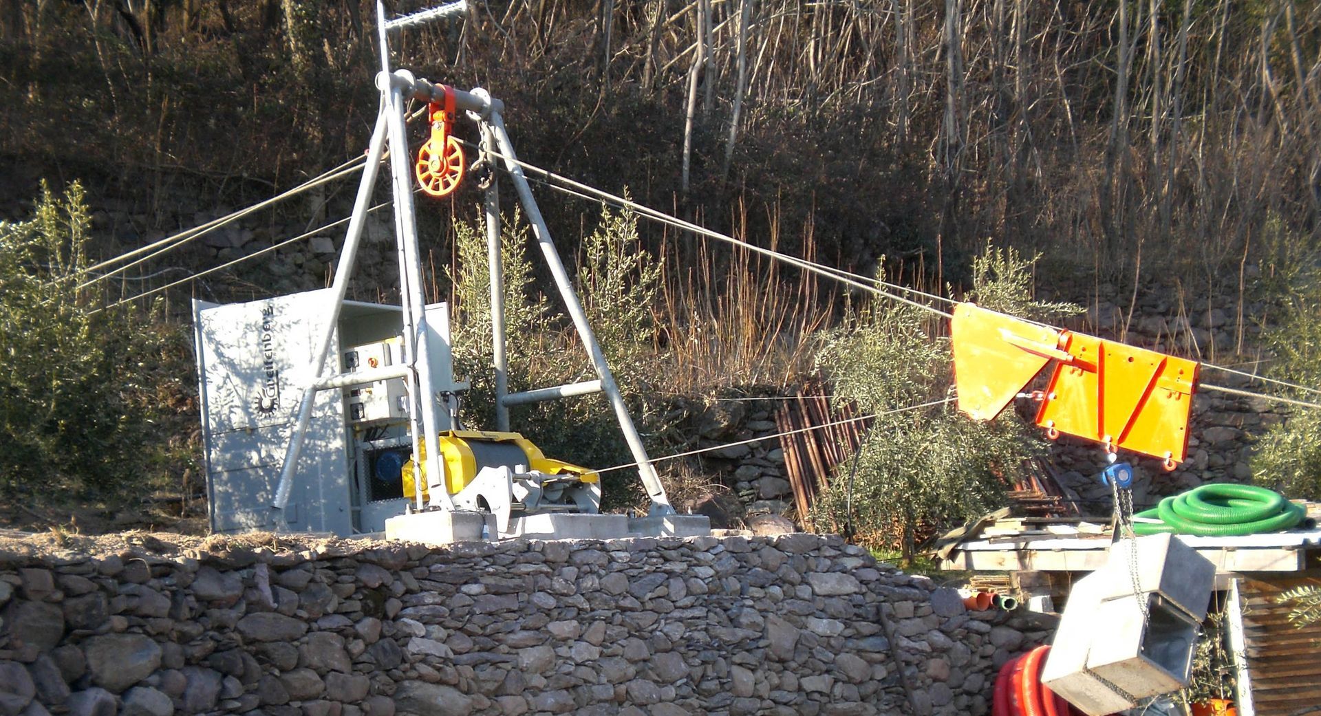 Un sistema di verricelli su una collina. Una carrucola è in cima a un telaio. È presente anche una bandiera arancione.