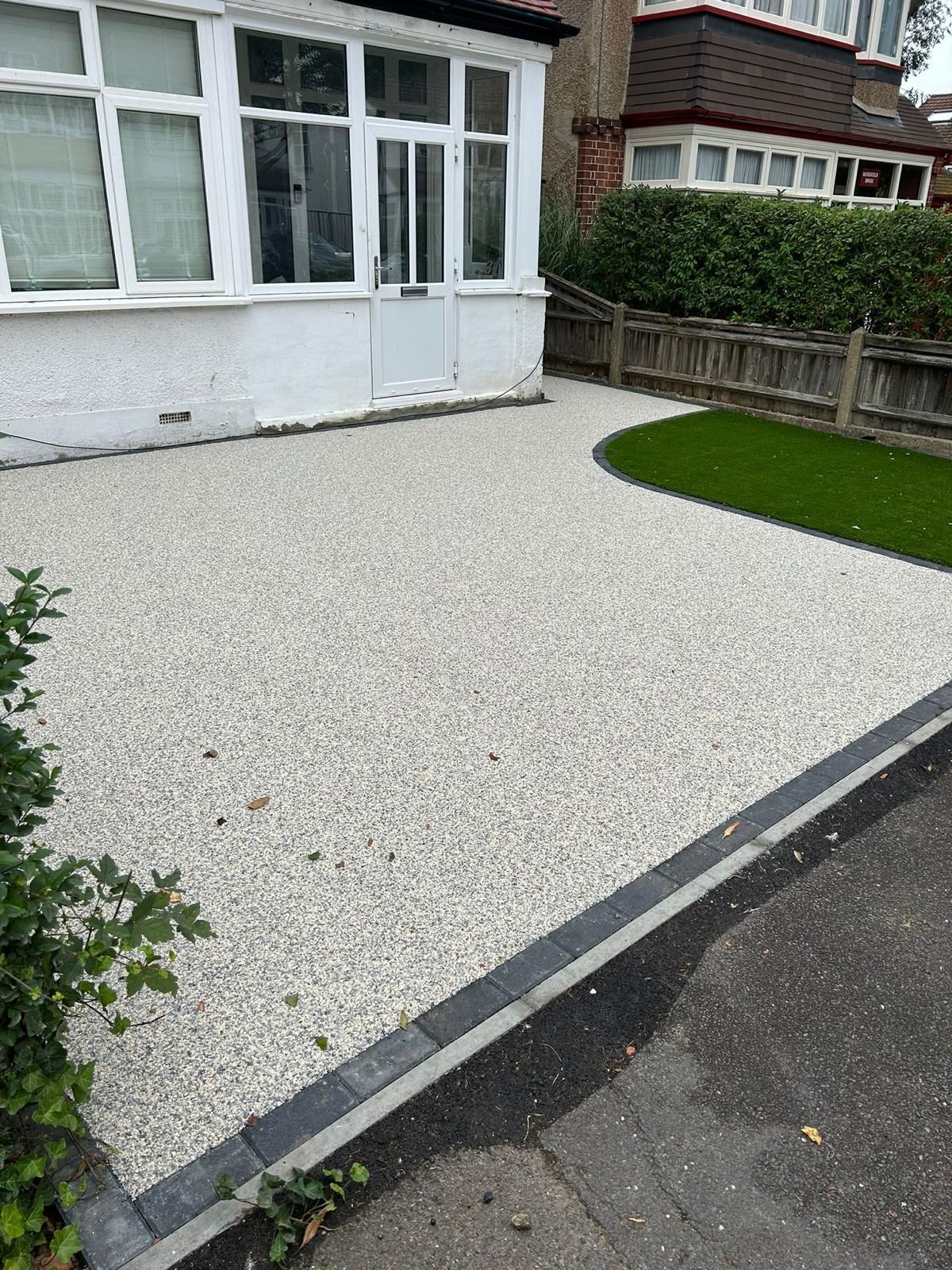 There is a gravel driveway in front of a house.
