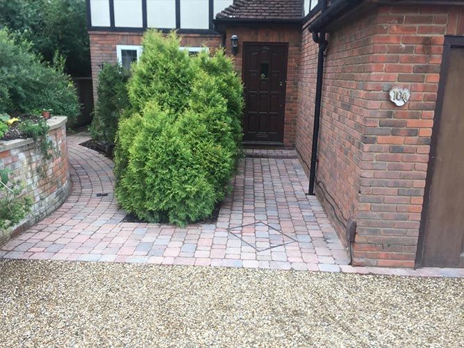 A brick walkway leading to the front door of a house.