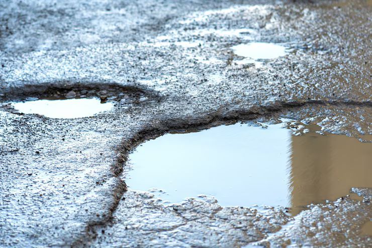 close up picture of a road with big potholes