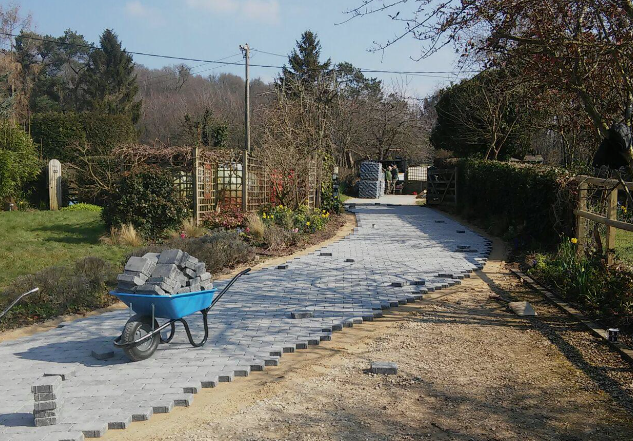 A wheelbarrow filled with rocks is on a dirt road.