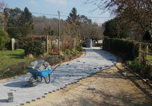 A wheelbarrow filled with rocks is on a dirt road.
