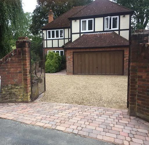 A path leading to a patio in a garden with a pergola.