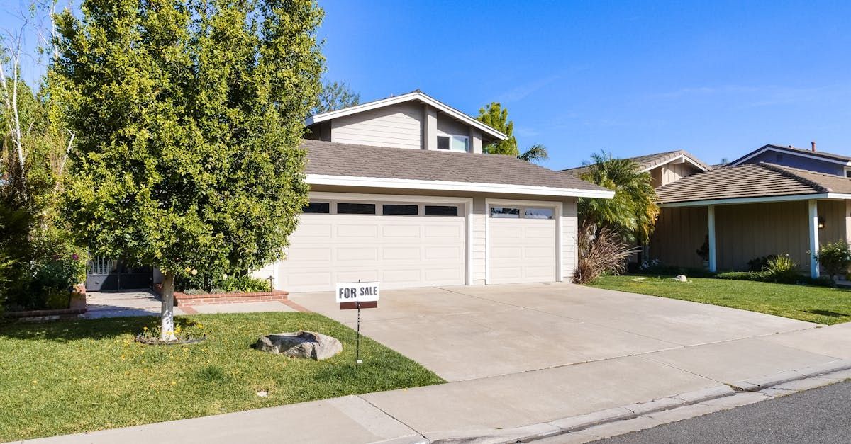 A house with two garage doors and a mailbox in front of it.