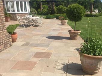 A patio with a table and chairs and plant pots.