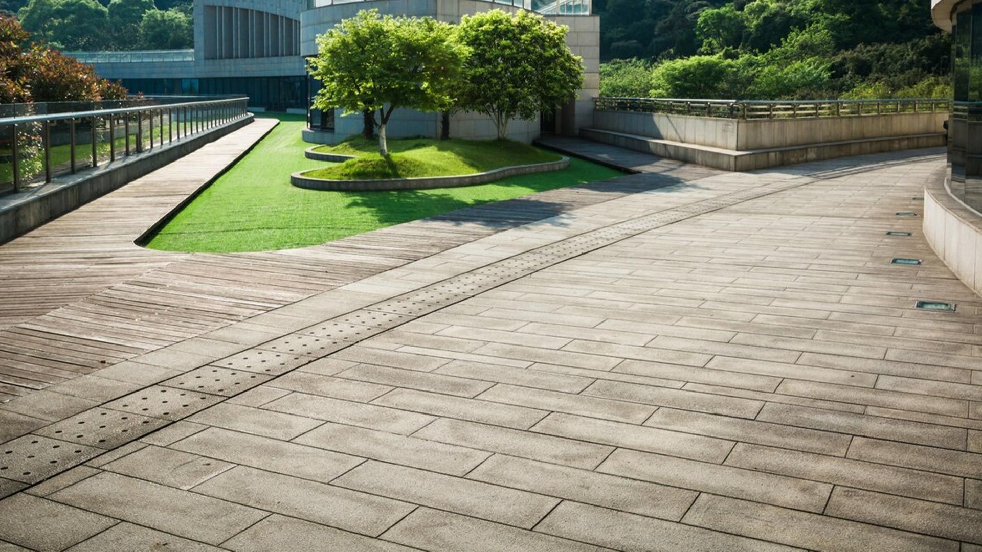 A brick walkway leading to a building with trees in the background.