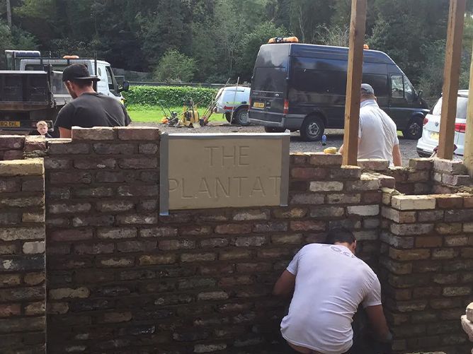 A brick wall with a sign that says the planta on it