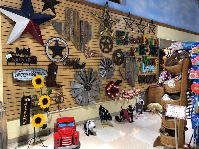 A selection of outdoor decor featuring lettered metal signs, flowers, & Texas star.