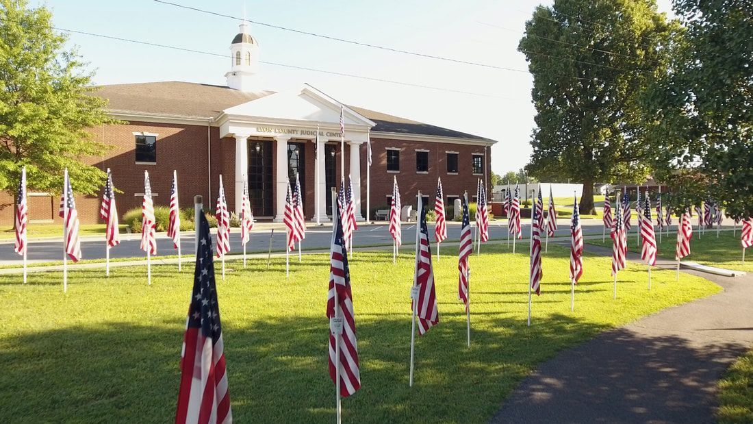 A row of american flags are lined up in front of a building.