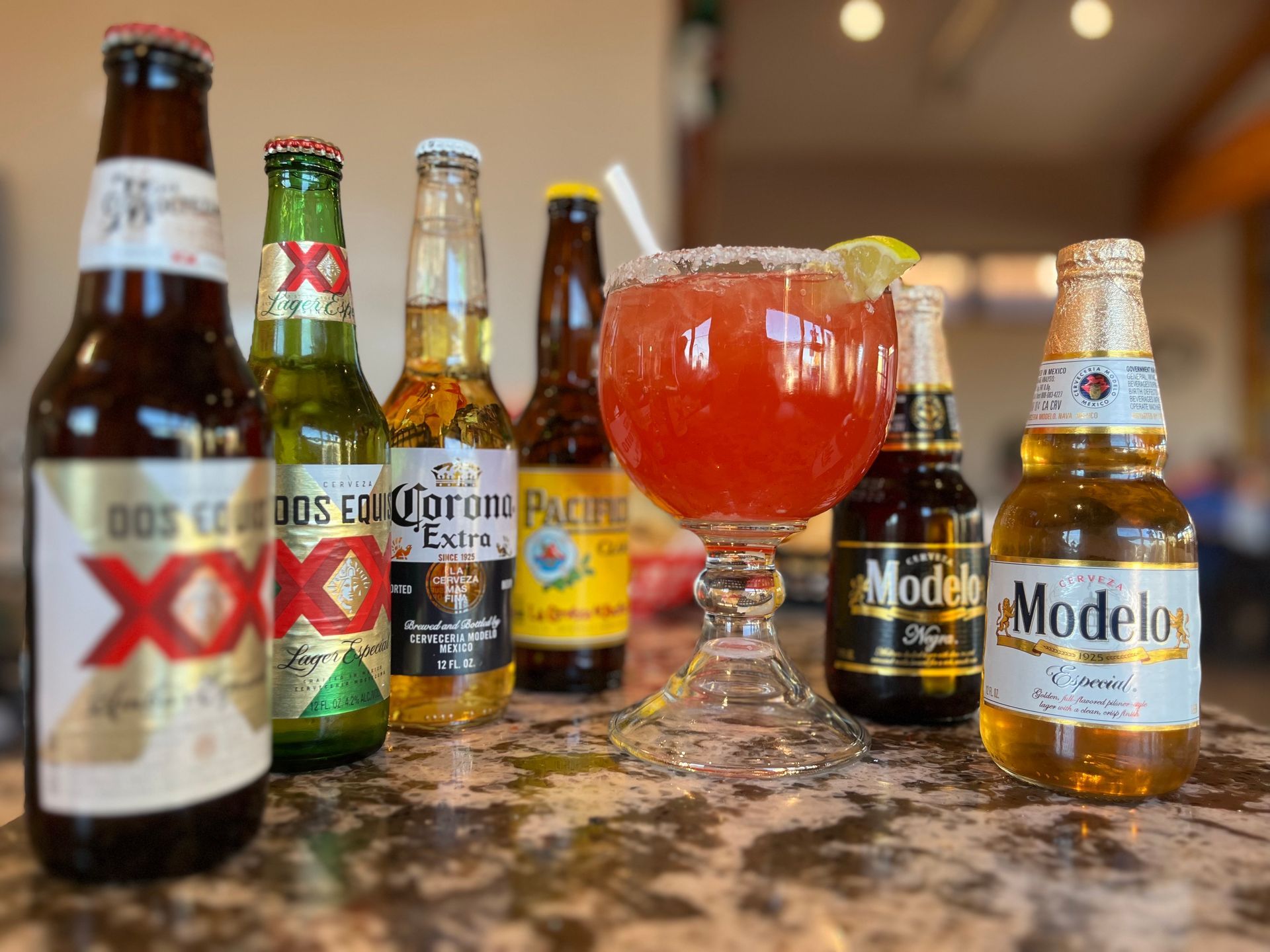 A table topped with bottles of beer and a glass of beer.
