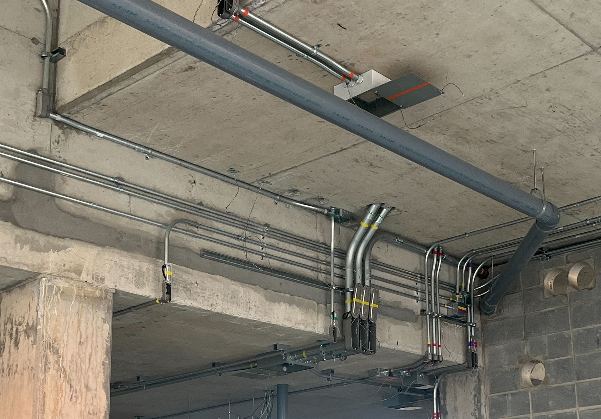 A bunch of pipes are hanging from the ceiling of a building.
