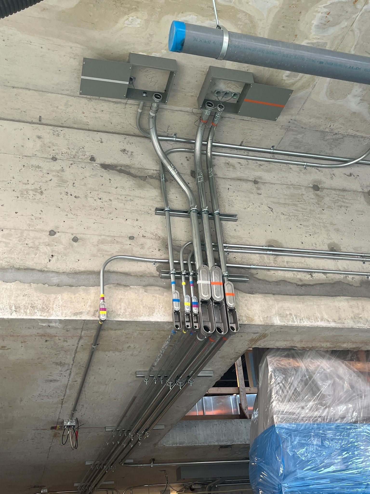 A bunch of pipes are hanging from the ceiling of a building.