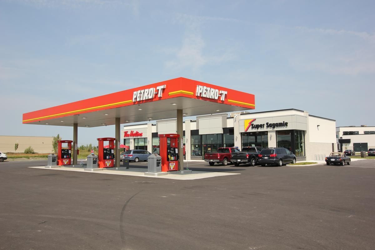 A gas station with cars parked in front of it
