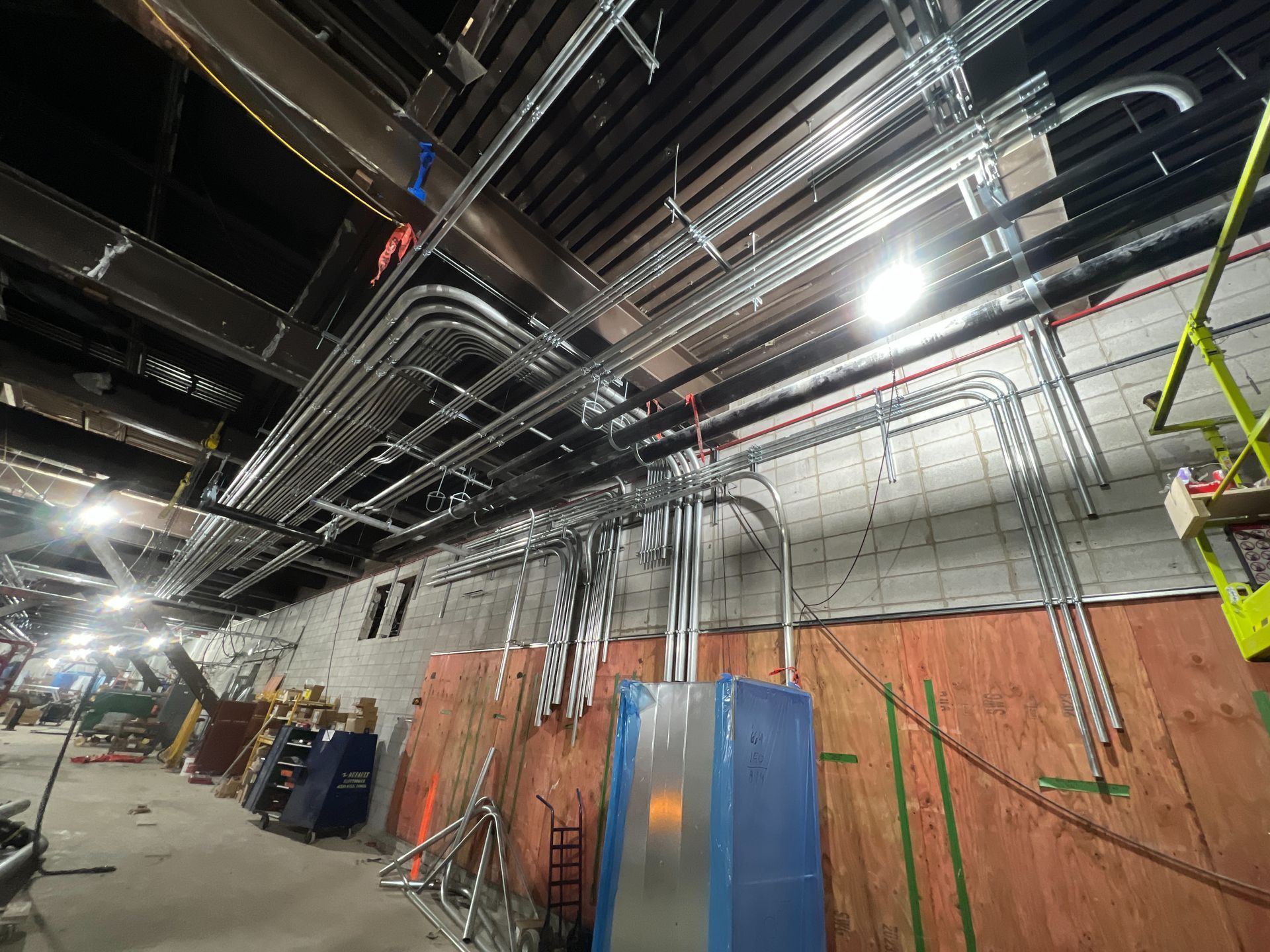 A large room with a lot of pipes hanging from the ceiling.