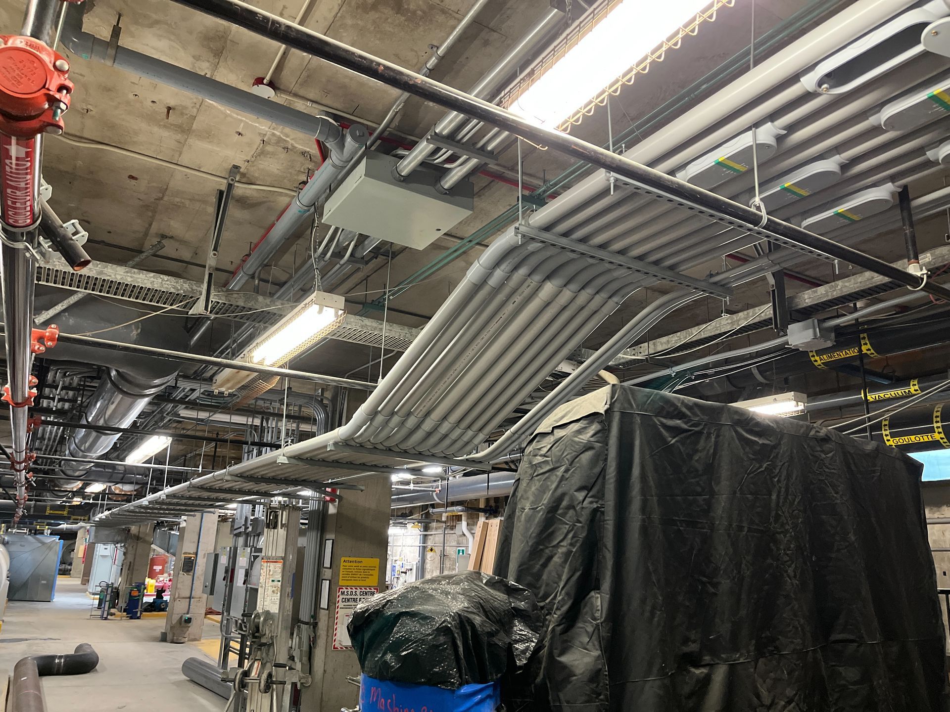 A bunch of pipes are hanging from the ceiling of a building.