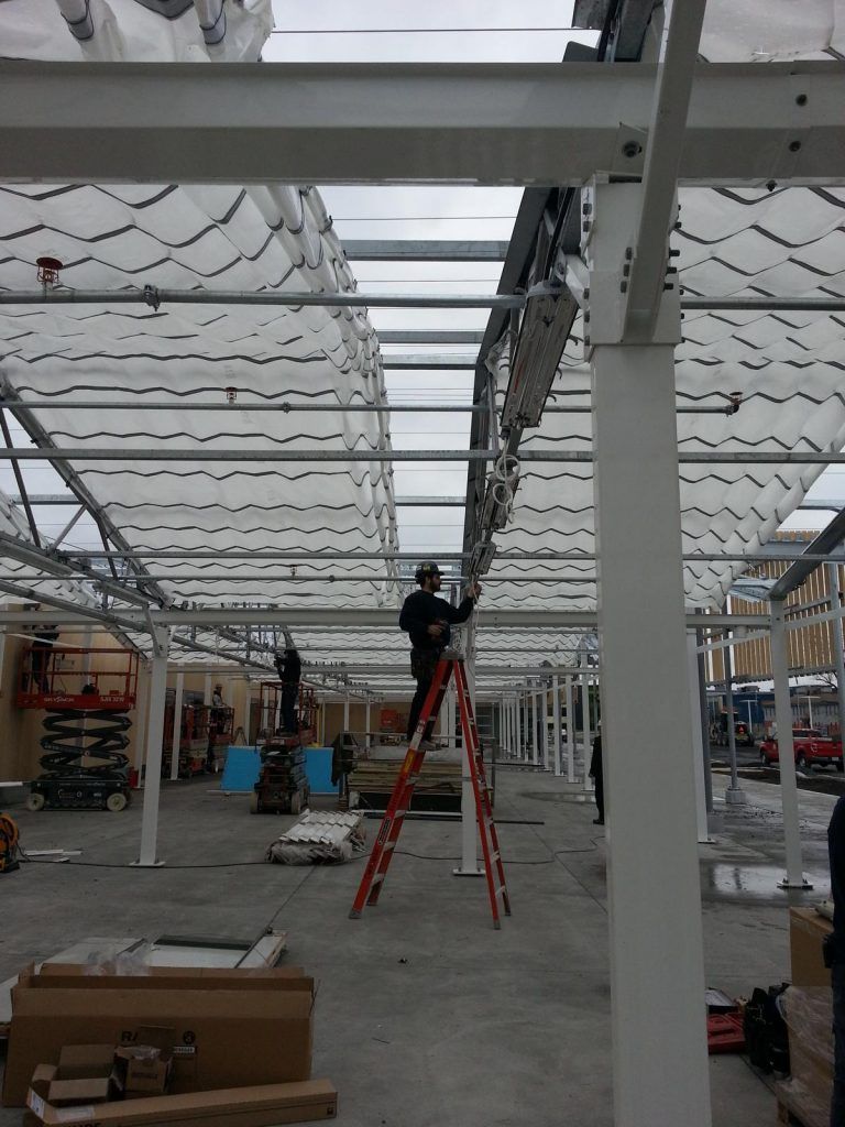 A man is standing on a ladder in a building under construction.