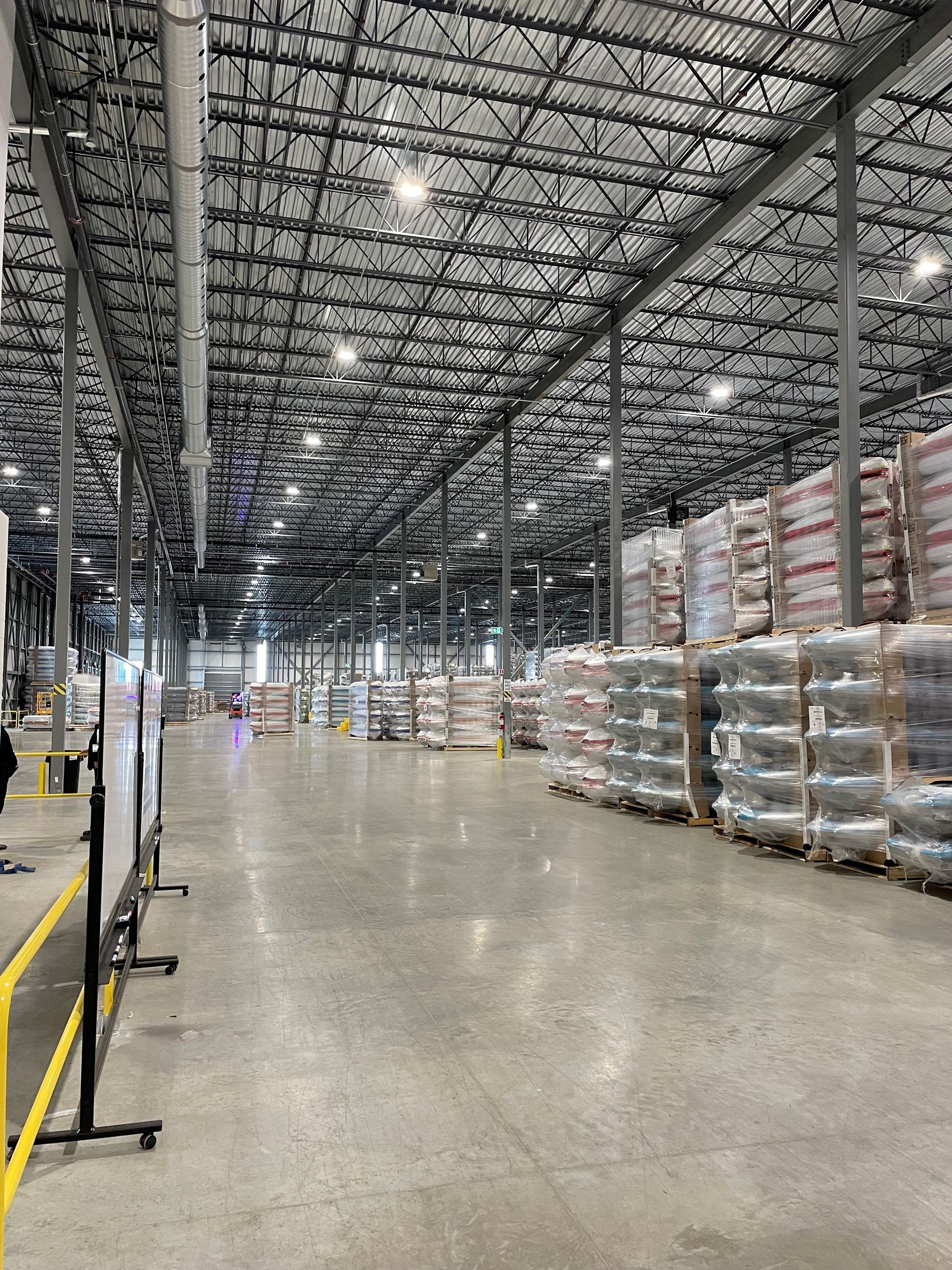 A large warehouse filled with lots of pallets and boxes.